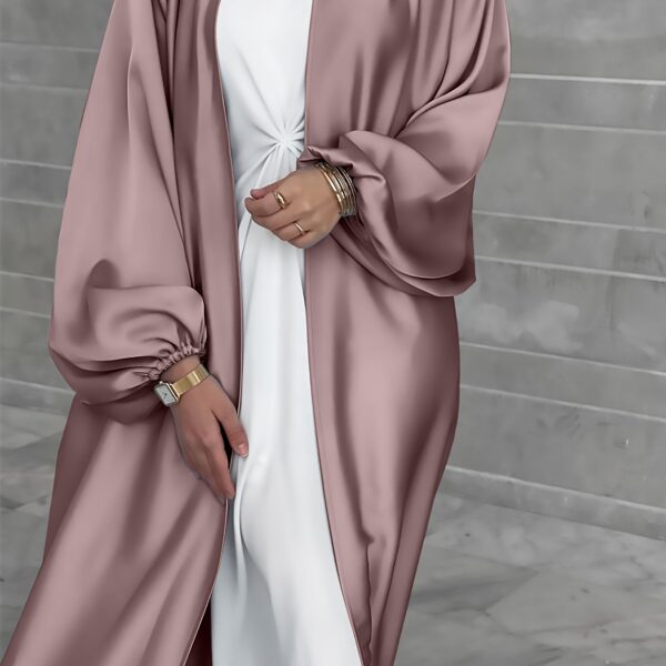 Model wearing Newness's Serene Sands Satin Abaya, a flowing maxi dress in luxurious satin fabric. The abaya is elegantly styled and perfect for any occasion.