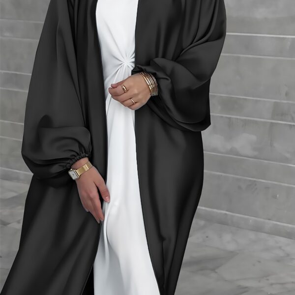 Model wearing Newness's Serene Sands Satin Abaya, a flowing maxi dress in luxurious satin fabric. The abaya is elegantly styled and perfect for any occasion.