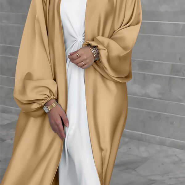 Model wearing Newness's Serene Sands Satin Abaya, a flowing maxi dress in luxurious satin fabric. The abaya is elegantly styled and perfect for any occasion.