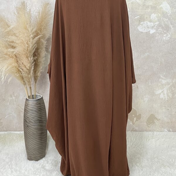 Desert Bloom Batwing Abaya in a flattering pose on a model, highlighting its flowing fabric and elegant design.