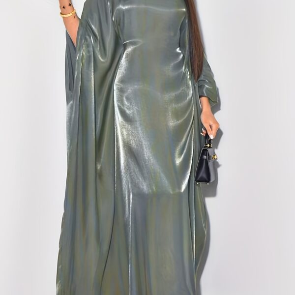 Model wearing Newness's Celestial Shimmer Metallic Abaya, a flowing maxi dress with a metallic shimmer, perfect for any occasion.