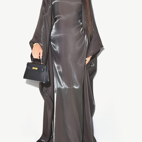 Model wearing Newness's Celestial Shimmer Metallic Abaya, a flowing maxi dress with a metallic shimmer, perfect for any occasion.