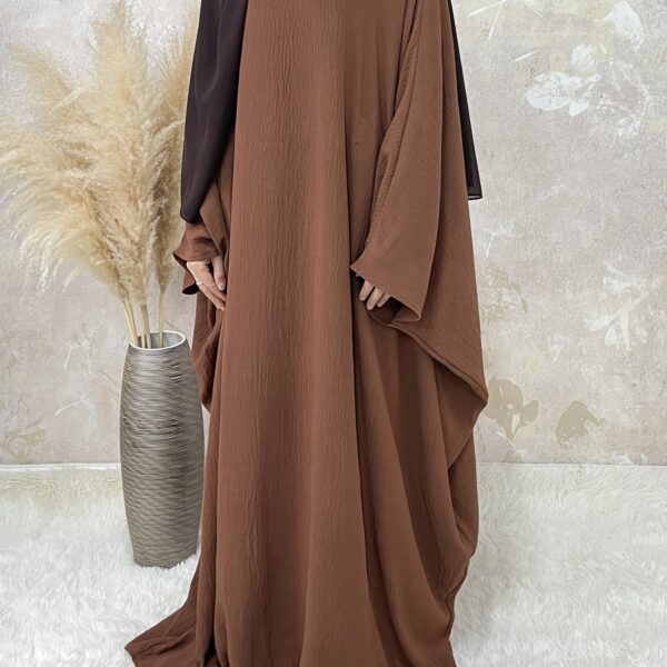 Desert Bloom Batwing Abaya in a flattering pose on a model, highlighting its flowing fabric and elegant design.