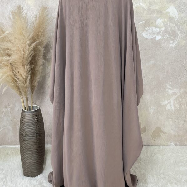 Desert Bloom Batwing Abaya in a flattering pose on a model, highlighting its flowing fabric and elegant design.