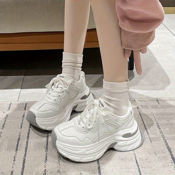Newness CloudWalk Platform Sneakers in white, showcasing the chunky platform sole and sleek design. Model is walking, demonstrating comfort and style.