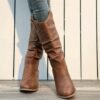 Newness Sunset Rider Ruched Cowboy Boots Brown leather cowboy boots with ruched detailing shown from the side in a lifestyle shot