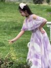 Adorable girl twirling in a flowy elegant chiffon dress perfect for summer The dress is in a beautiful summer garden setting
