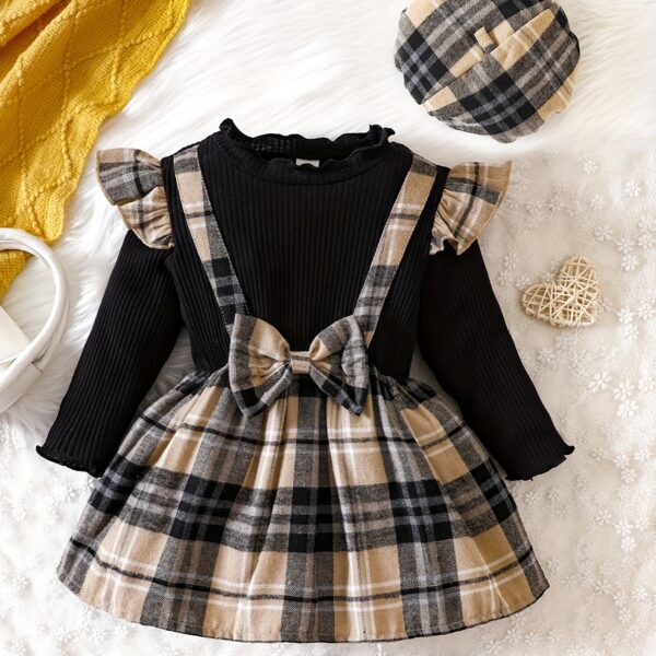 Adorable girl wearing a red and white plaid dress and matching beret. Perfect for spring or fall.