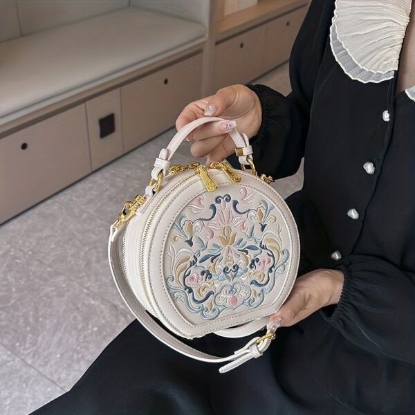 Vienna Embroidered Crossbody Bag in chic faux leather with golden hardware and unique embroidered design.