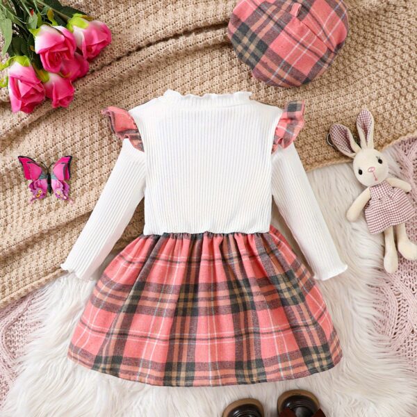 Adorable girl wearing a red and white plaid dress and matching beret. Perfect for spring or fall.