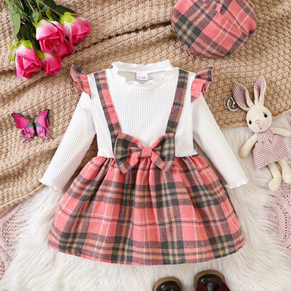 Adorable girl wearing a red and white plaid dress and matching beret. Perfect for spring or fall.