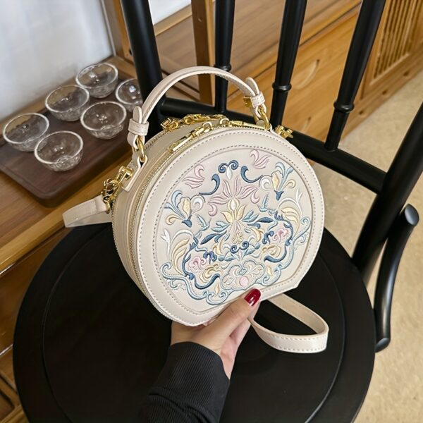 Vienna Embroidered Crossbody Bag in chic faux leather with golden hardware and unique embroidered design.