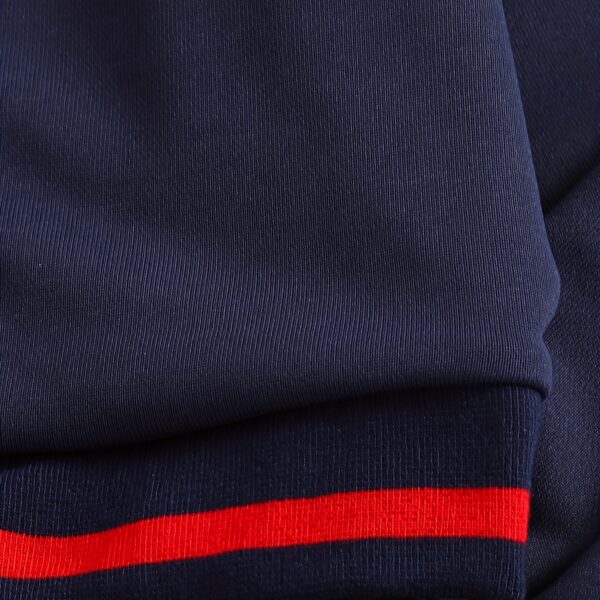 Stylish preppy varsity jacket and skirt set in navy and cream, modeled on a student in a school setting