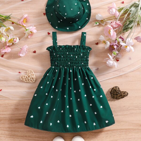 Girl wearing adorable Summer Bloom heart print dress and matching hat set.