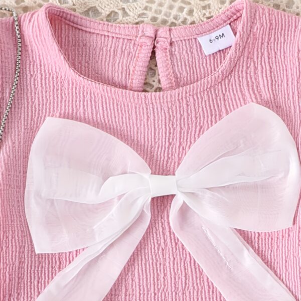 Adorable toddler girl in a stylish summer outfit, featuring a cute bow. Shop Newness for more children's fashion.