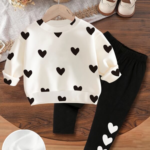 Adorable girls' playful set featuring a sweet heart print, perfect for fall and winter. The outfit includes [mention pieces included, e.g., a sweater and leggings] in soft, comfortable fabrics.