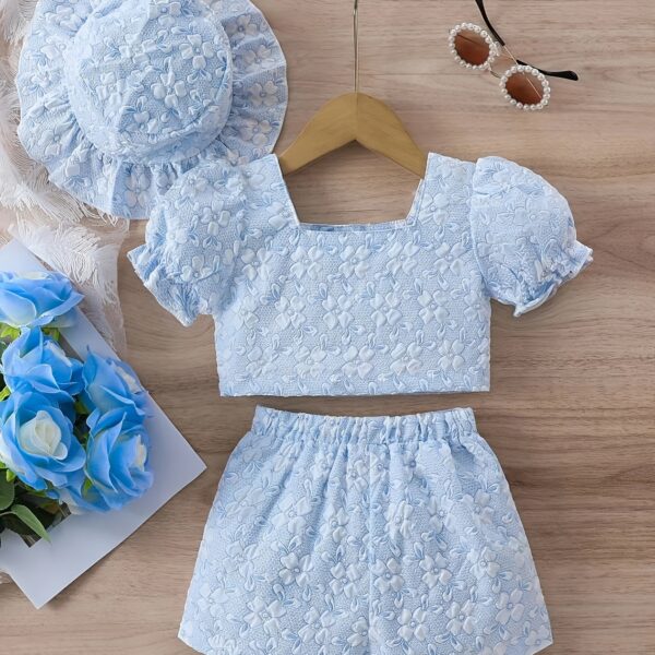 Adorable baby girl wearing a Summer Bloom floral outfit, perfect for summer. The outfit features a delightful floral pattern.