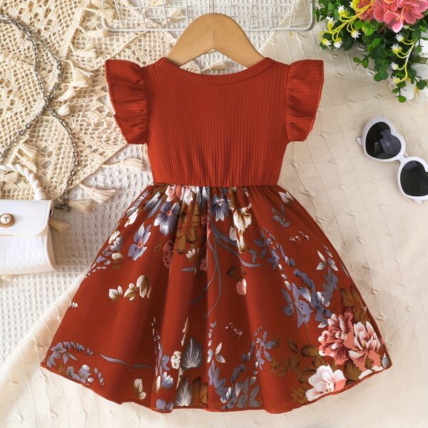 Adorable girl wearing a vibrant Summer Bloom floral print dress, perfect for summer. The dress features a playful, colorful floral pattern.