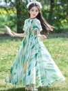 Adorable girl twirling in a flowy elegant chiffon dress perfect for summer The dress is in a beautiful summer garden setting