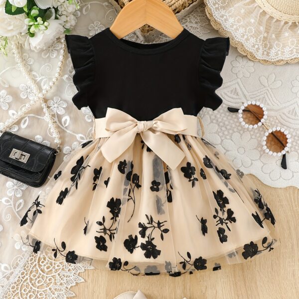 Adorable little girl twirling in a beautiful summer floral mesh dress from Newness. The dress is lightweight and perfect for warm weather.
