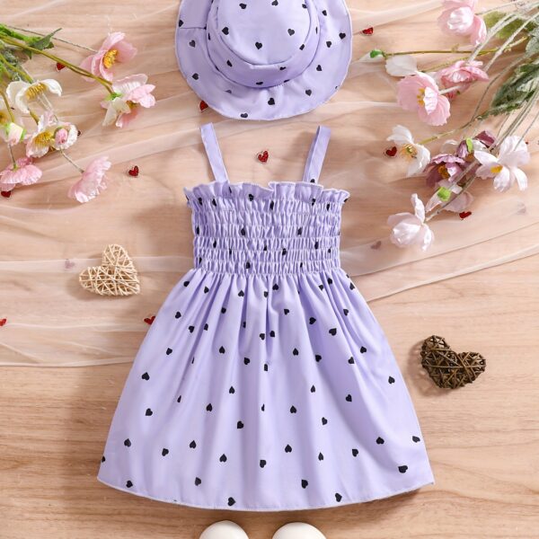 Girl wearing adorable Summer Bloom heart print dress and matching hat set.