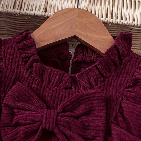 Adorable baby girl wearing a charming corduroy dress, perfect for playtime or special occasions.
