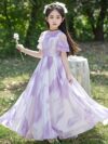 Adorable girl twirling in a flowy elegant chiffon dress perfect for summer The dress is in a beautiful summer garden setting