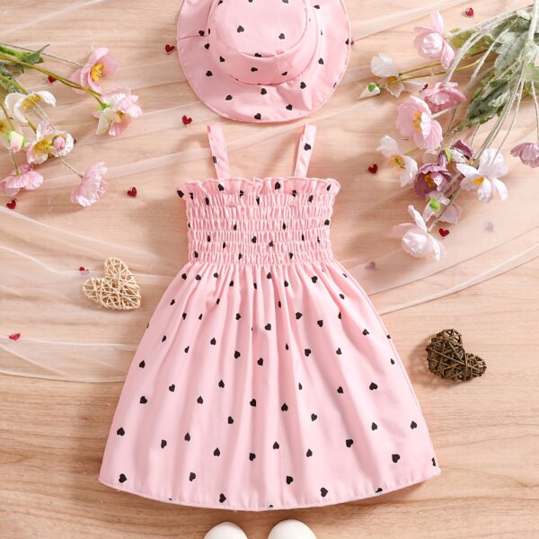 Girl wearing adorable Summer Bloom heart print dress and matching hat set.
