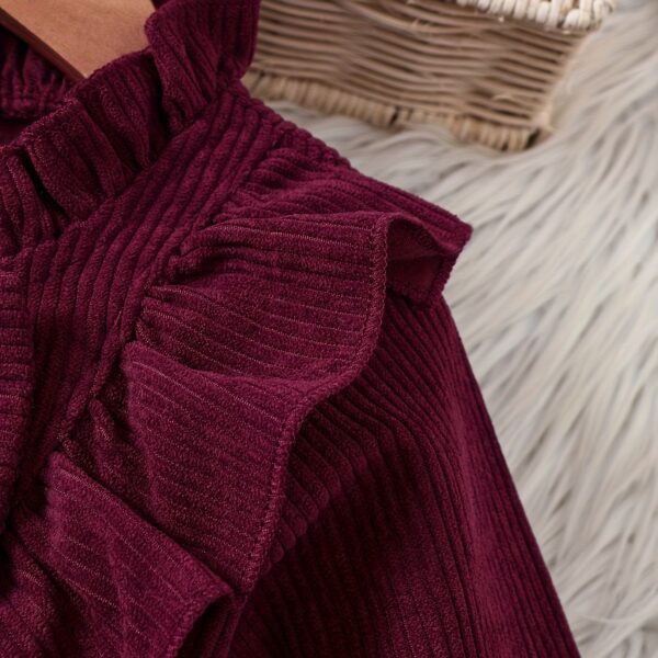 Adorable baby girl wearing a charming corduroy dress, perfect for playtime or special occasions.