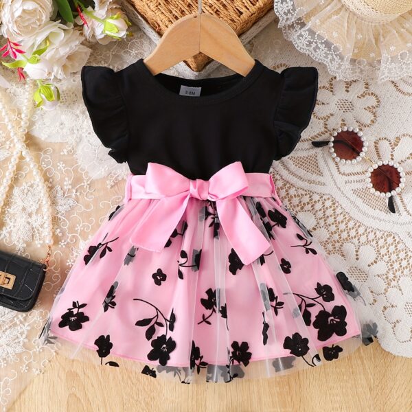 Adorable little girl twirling in a beautiful summer floral mesh dress from Newness. The dress is lightweight and perfect for warm weather.