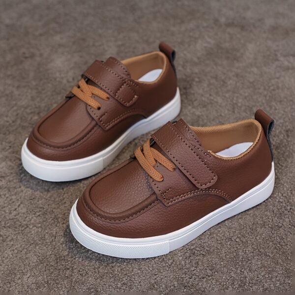 Close-up of stylish brown leather boys loafers, showcasing the stitching and buckle detail.
