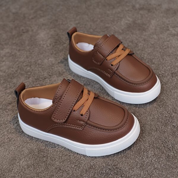 Close-up of stylish brown leather boys loafers, showcasing the stitching and buckle detail.