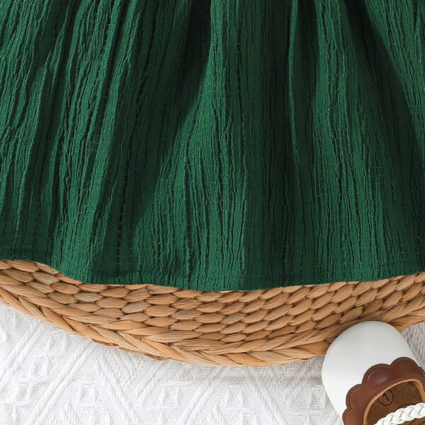 Toddler girl wearing a charming emerald green summer dress, ideal for playing outdoors.