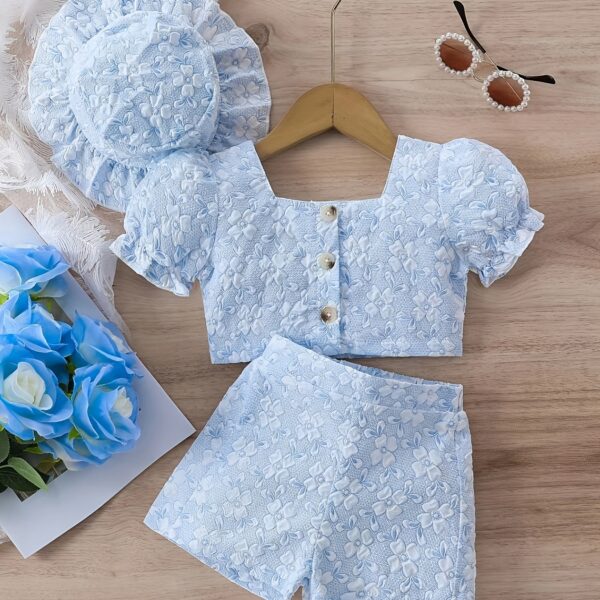 Adorable baby girl wearing a Summer Bloom floral outfit, perfect for summer. The outfit features a delightful floral pattern.