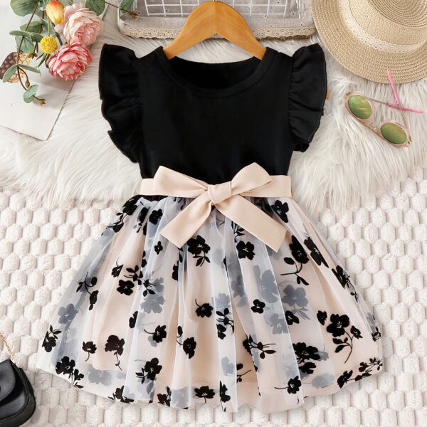 Adorable little girl twirling in a vibrant Summer Bloom floral print dress from Newness, perfect for summer.