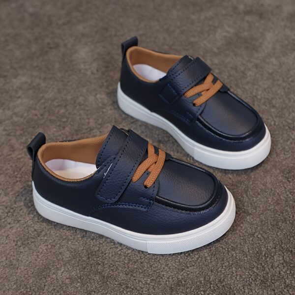 Close-up of stylish brown leather boys loafers, showcasing the stitching and buckle detail.