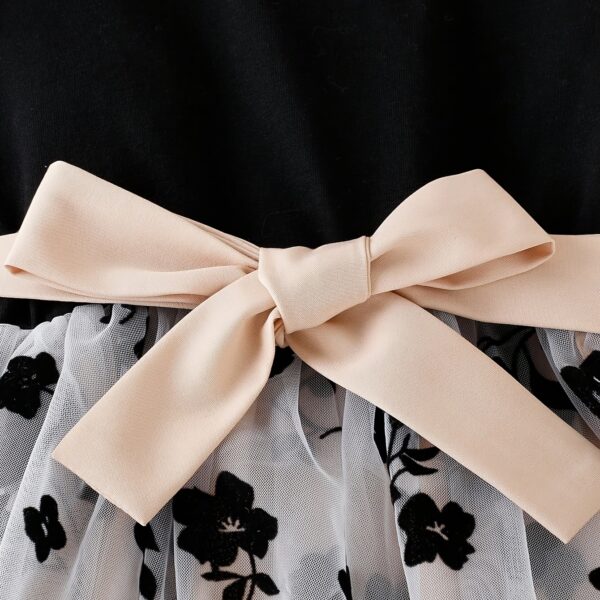 Adorable little girl twirling in a vibrant Summer Bloom floral print dress from Newness, perfect for summer.