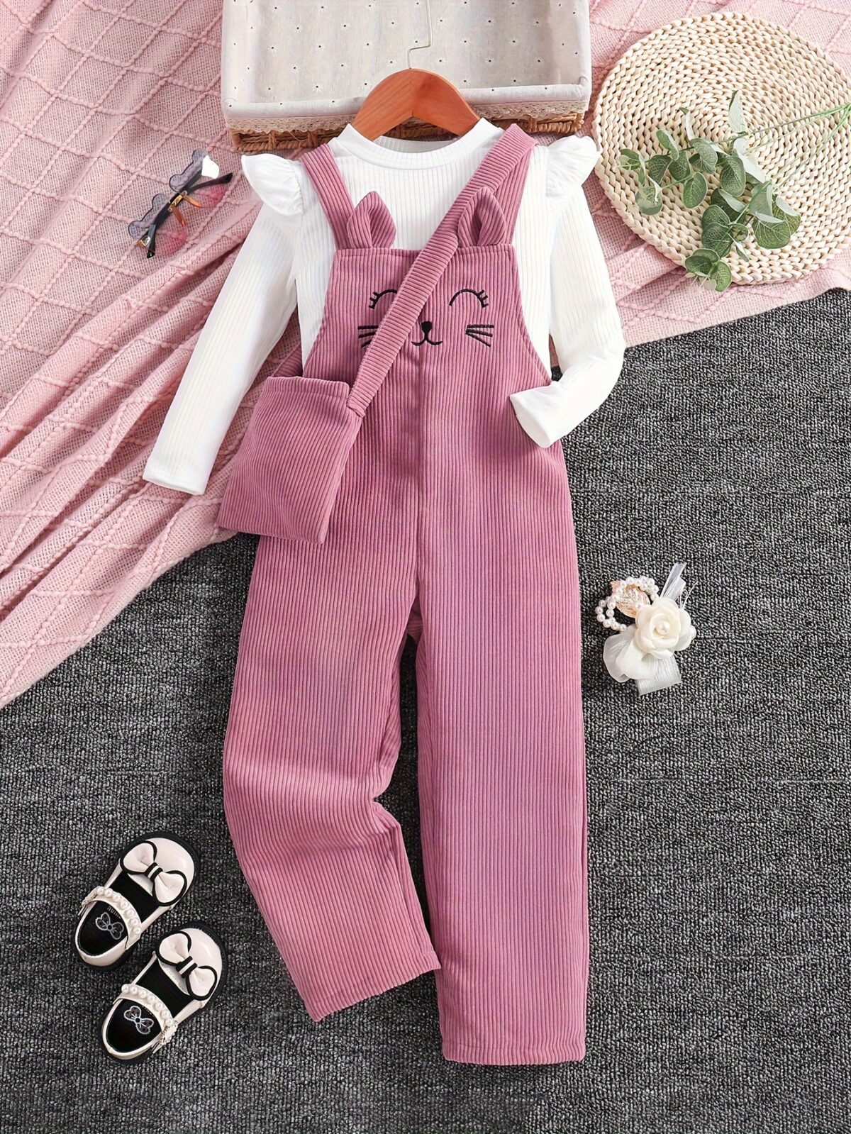 Adorable little girl wearing a playful cat embroidered jumpsuit perfect for spring or autumn The jumpsuit is comfortable and stylish