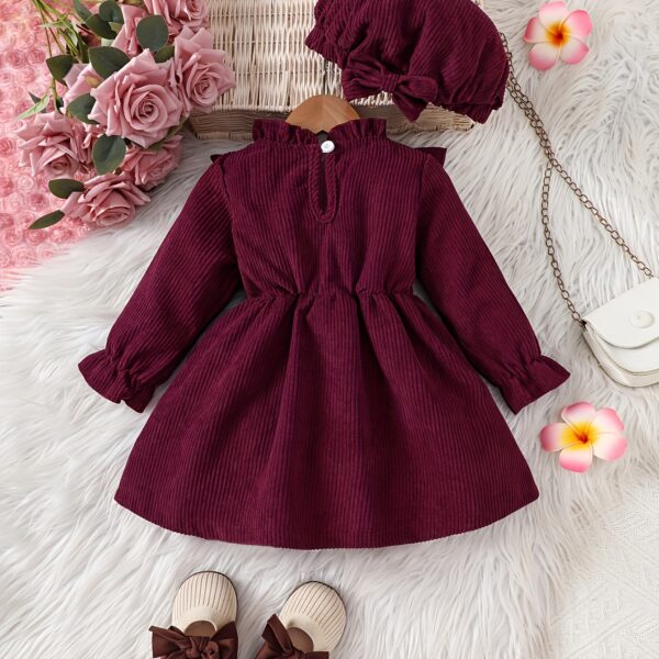 Adorable baby girl wearing a charming corduroy dress, perfect for playtime or special occasions.