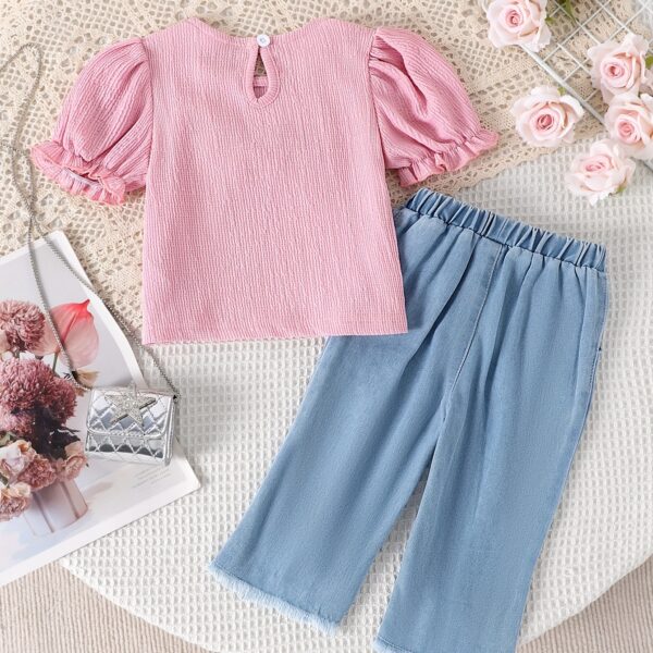 Adorable toddler girl in a stylish summer outfit, featuring a cute bow. Shop Newness for more children's fashion.