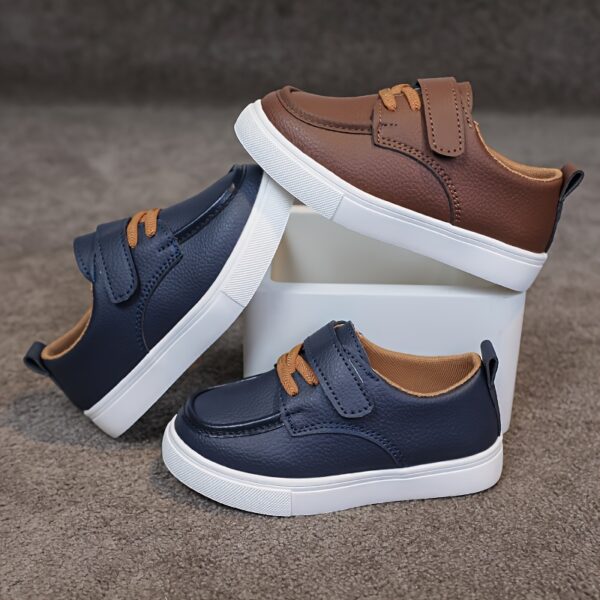 Close-up of stylish brown leather boys loafers, showcasing the stitching and buckle detail.