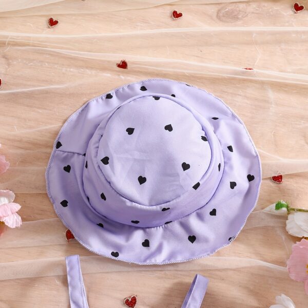 Girl wearing adorable Summer Bloom heart print dress and matching hat set.