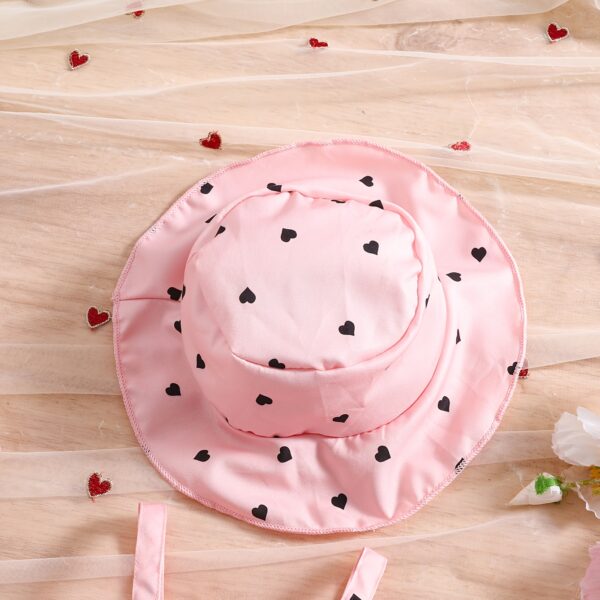Girl wearing adorable Summer Bloom heart print dress and matching hat set.