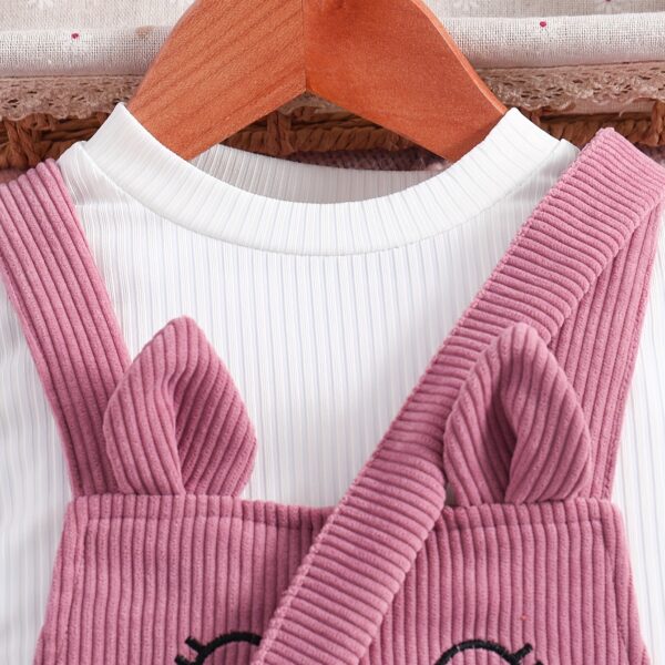 Adorable little girl wearing a playful cat embroidered jumpsuit, perfect for spring or autumn. The jumpsuit is comfortable and stylish.