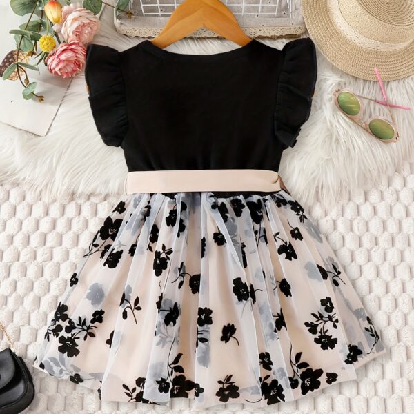 Adorable little girl twirling in a vibrant Summer Bloom floral print dress from Newness, perfect for summer.