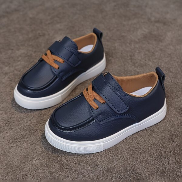Close-up of stylish brown leather boys loafers, showcasing the stitching and buckle detail.