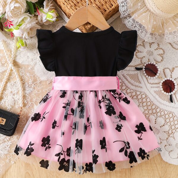 Adorable little girl twirling in a beautiful summer floral mesh dress from Newness. The dress is lightweight and perfect for warm weather.