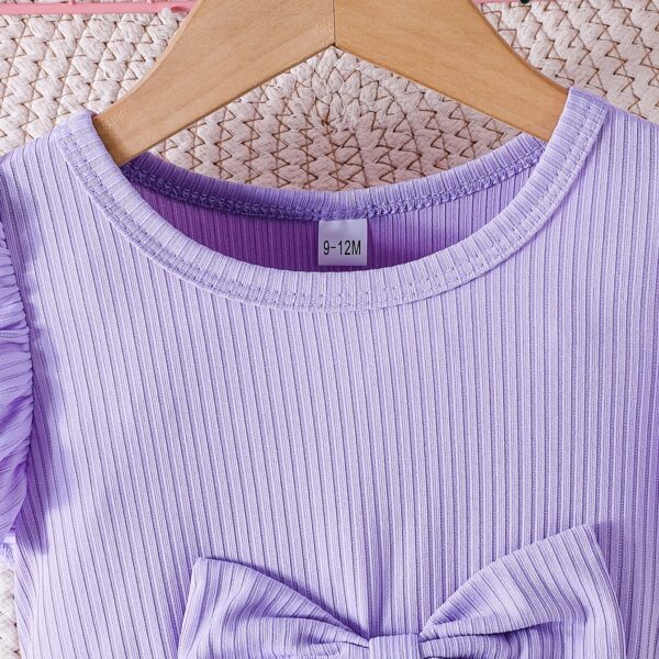 Adorable baby girl wearing a charming butterfly print dress from Newness, perfect for spring and summer.