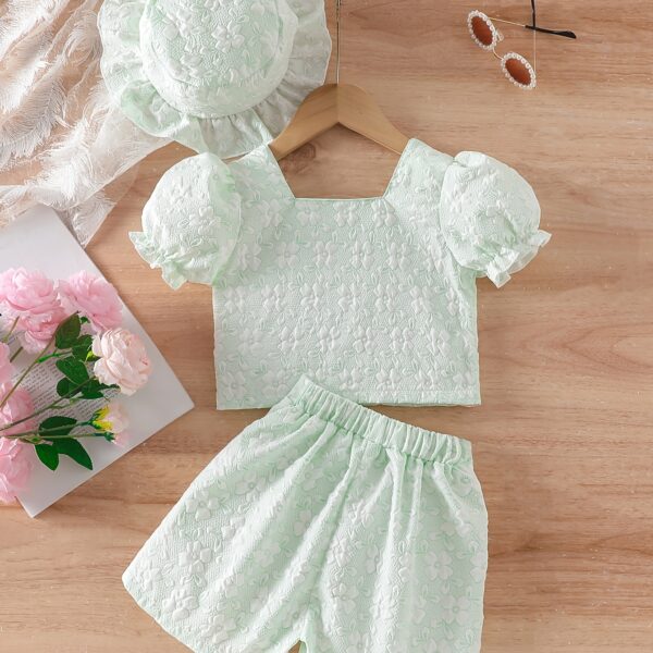 Adorable baby girl wearing a Summer Bloom floral outfit, perfect for summer. The outfit features a delightful floral pattern.