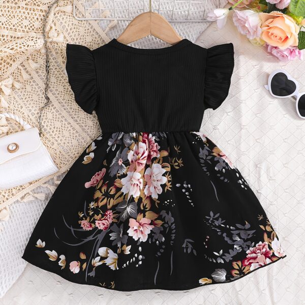 Adorable girl wearing a vibrant Summer Bloom floral print dress, perfect for summer. The dress features a playful, colorful floral pattern.